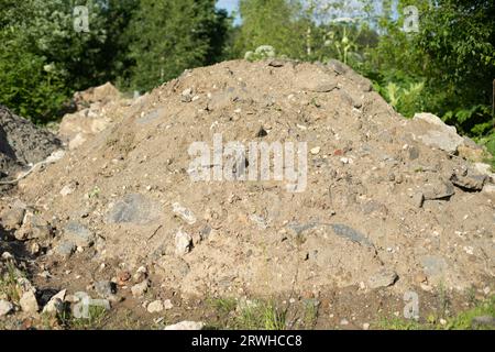 Mountain of construction debris. Excavated earth. Discarded cement. Illegal garbage dumping. Stock Photo