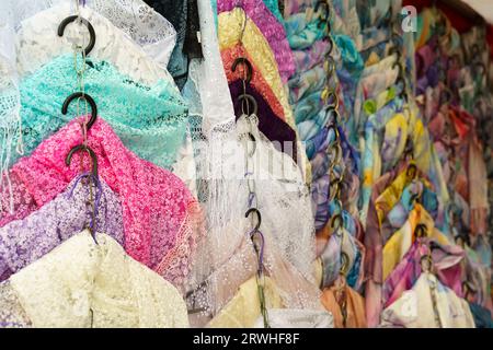 Multi-colored scarves on the counter of a trade tent at a fair. Selective sharpening, background. Small business. Stock Photo