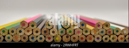 A selection of coloured pencils carefully placed in formation on a white surface under studio lighting. Stock Photo