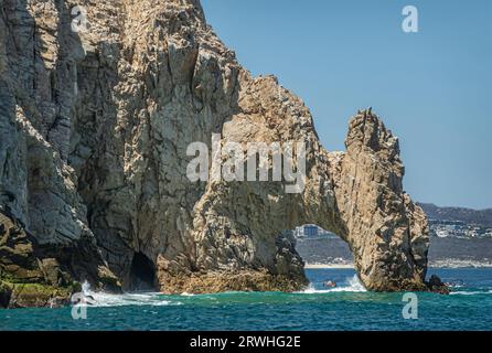 Mexico, Cabo San Lucas - July 16, 2023: South view on El Arco at Reserva de Los Marina. Cityscape and beach on horizon. Other side, small tourist sigh Stock Photo