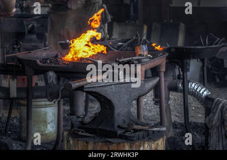 Blacksmith Forge and Tools - anvil and hammer in focus Stock Photo
