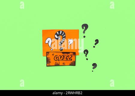 Paper quiz card with question marks on green background Stock Photo
