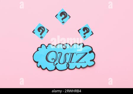 Word QUIZ in speech bubble with question marks on pink background Stock Photo