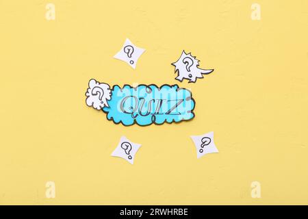 Word QUIZ in speech bubble with question marks on yellow background Stock Photo