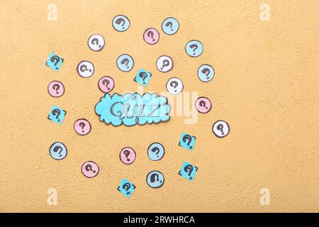 Word QUIZ in speech bubble with question marks on orange background Stock Photo