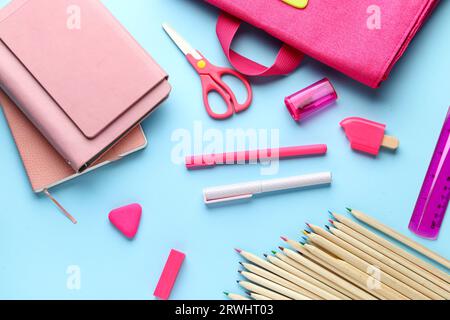 Composition with notebooks and different pink stationery on blue background Stock Photo