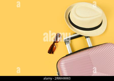 Stylish hat, sunglasses and suitcase on color background Stock Photo