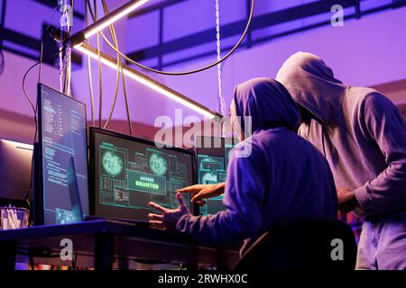 Hackers celebrating successful hacking attempt and getting access granted to database sensitive data. Happy criminals breaking computer network system using malicious software Stock Photo