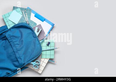 Stylish school backpack with different stationery on grey background Stock Photo