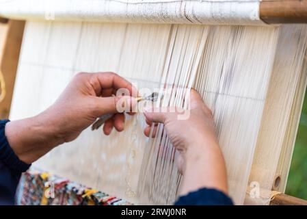 Carpet weaving using traditional techniques on a loom. , close-up of weaving and handmade carpet production. Stock Photo