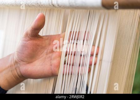 Carpet weaving using traditional techniques on a loom. , close-up of weaving and handmade carpet production. Stock Photo