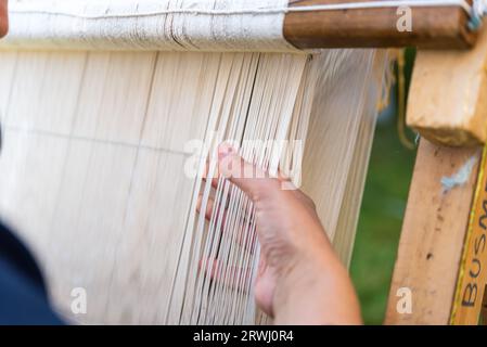 Carpet weaving using traditional techniques on a loom. , close-up of weaving and handmade carpet production. Stock Photo