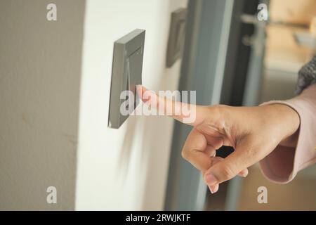 women finger turning on lighting switch . Stock Photo