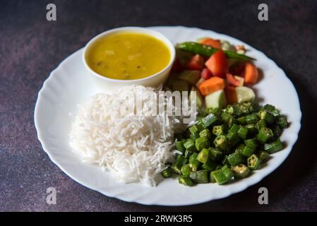 Healthy Indian veg meal rice, dal, vegetables and salad served in a plate. Stock Photo