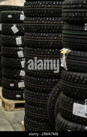 Sale of car tires for sale in the store. Many new winter tires lie Stock Photo