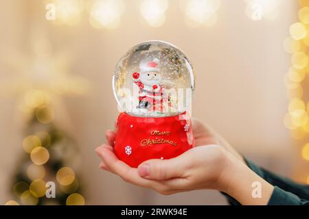 Close up of woman's hands holding snowglobe Stock Photo
