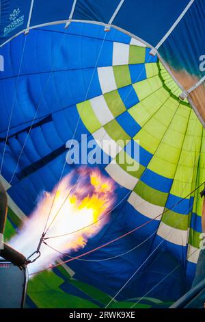 A blast of gas ignites, filling a hot air balloon with warm air on a cold winter's morning in Hunter Valley, New South Wales, Australia Stock Photo