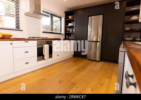 Spacious, modern kitchen with household appliances and wooden floor Stock Photo