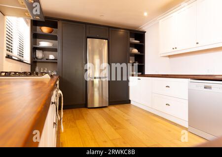 Spacious, modern kitchen with household appliances and wooden floor Stock Photo
