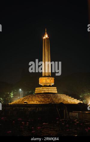 Portrait or vertical shot of Tugu Malang at night. Main landmark and tourist icon of Malang City in East Java, Indonesia. Malang Town Square. Stock Photo