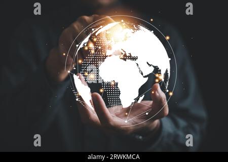 A businessman's hand holds a globe, illustrating seamless connectivity and data flow across global network Stock Photo