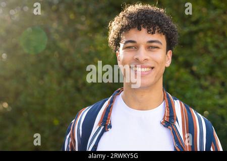 Portrait of happy biracial man standing in garden and smiling Stock Photo
