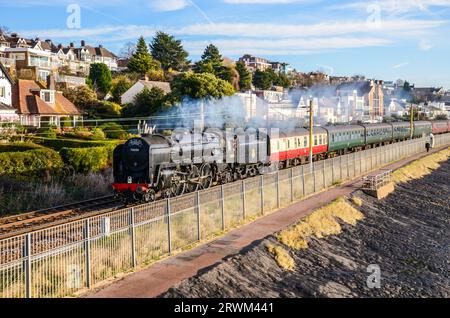 BR Standard Class 7 70000 Britannia steam locomotive hauling a steam special train from Southend, Essex passing Chalkwell beach by Thames Estuary Stock Photo