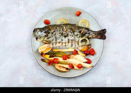 Grilled trout cooked with asparagus. Baked salmon fish served on plate Stock Photo