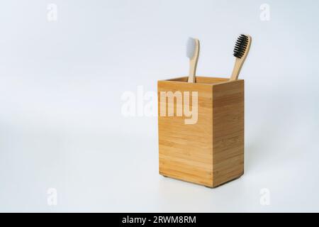 two toothbrushes in bamboo holder on white background. Eco friendly concept Stock Photo