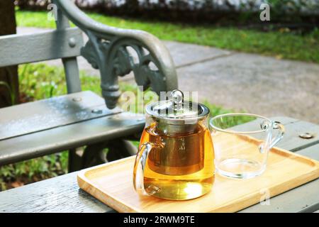 Closeup of Pot of hot tea with a cup on garden table Stock Photo