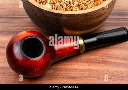 Fragrant smoking tobacco and a smoking tube or pipe on the table. Space ...