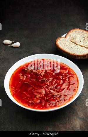 Borsch in plate on rough wooden table, a traditional Russian and Ukrainian soup. Borscht, a dish of Slavic cuisine Stock Photo