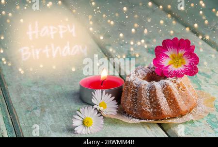 Happy Birthday - cute small bundt cake with candle and daisies on wood Stock Photo