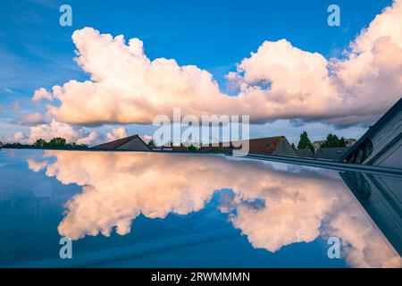 Row of cumulus clouds is reflected in a skylight on a sunny evening Stock Photo