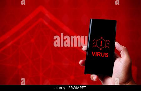 Hand holding smartphone with smartphone technology cyber security concept on red abstract background, copy space, virus attack to software system. Stock Photo