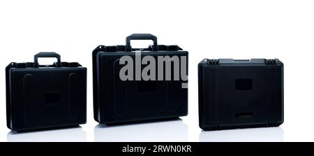 New toolbox or plastic case isolated on white background. Empty hard plastic suitcase with handle. Set of black plastic travel luggage. Modern case Stock Photo