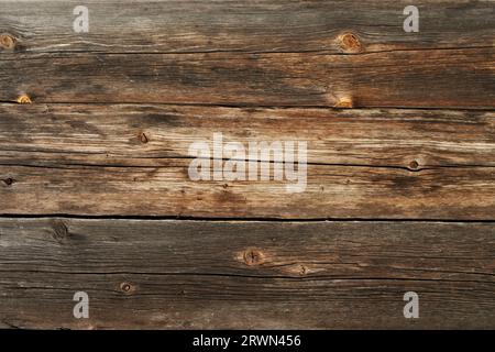 The cracked wooden wall of an old building. A fragment of a brown old wooden wall. Stock Photo