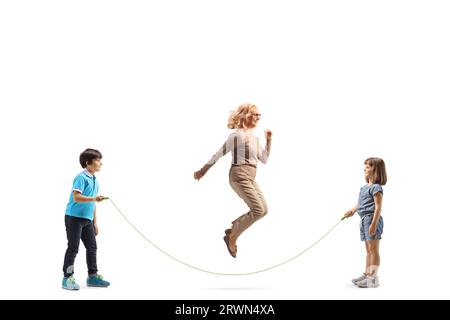 Girl and boy playing skipping rope with a mature woman isolated on white background Stock Photo