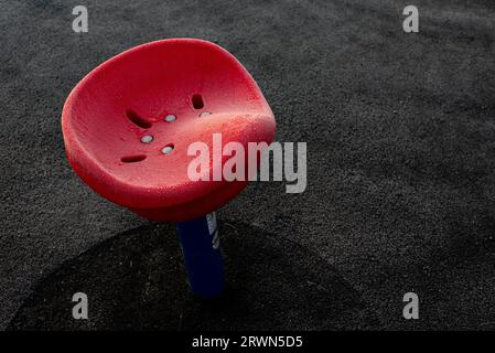 Red child's spinning seat in frozen playground Stock Photo