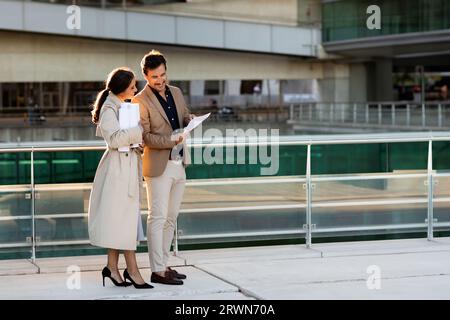 Mature man and woman engineers discussing project at construction site Stock Photo