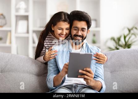 Positive loving indian couple using digital tablet at home Stock Photo
