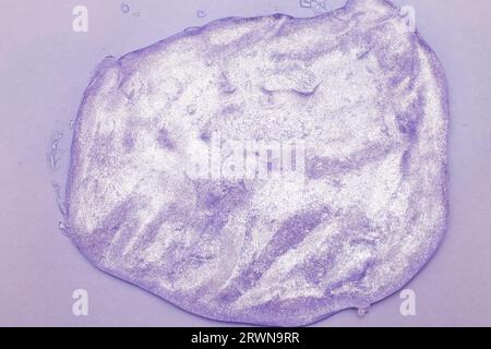 Glitter slime on purple background. Leisure for children concept. playing child games and love toys. Stock Photo