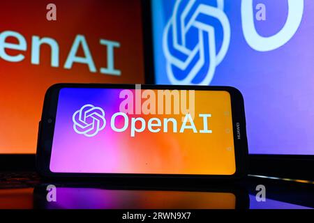 In this photo illustration a Open AI logo is displayed on a smartphone and in the background. Stock Photo