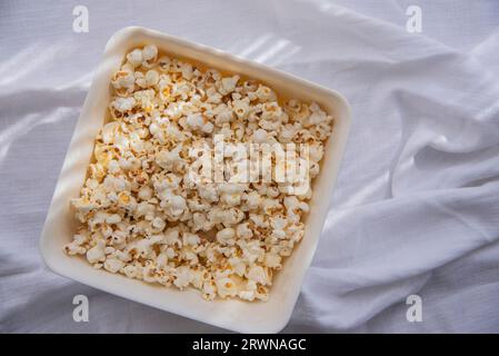 white homemade popcorn in a white bowl , close up. A bowl of freshly popped popcorn Stock Photo