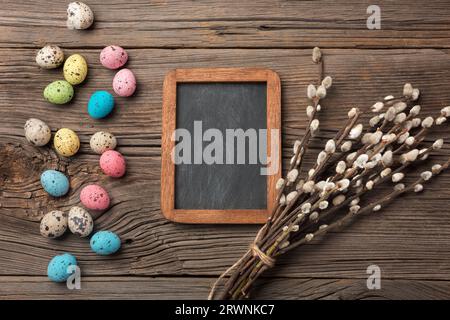 Colorful easter eggs and brushes on wooden table. Top view with copy space. Stock Photo