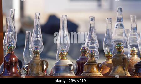 Classic kerosene lamps with glass cylinders displayed in a stall at a traditional pottery market. Stock Photo