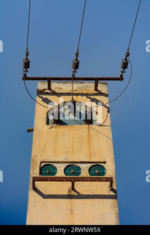 Brick tower on the street with old electrical installation and electrical cables Stock Photo