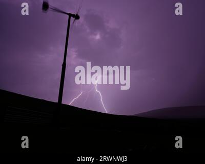 Fork lightning behind wind turbine, Orkney Islands Stock Photo