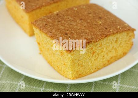 Pumpkin sponge cake pieces lying on a white plate. Close up. Stock Photo