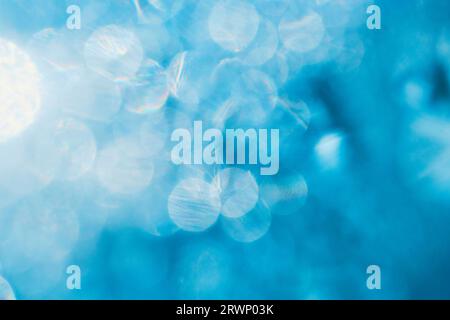 Abstract blue background with round bokeh from raindrops on glass illuminated by bright sunlight Stock Photo